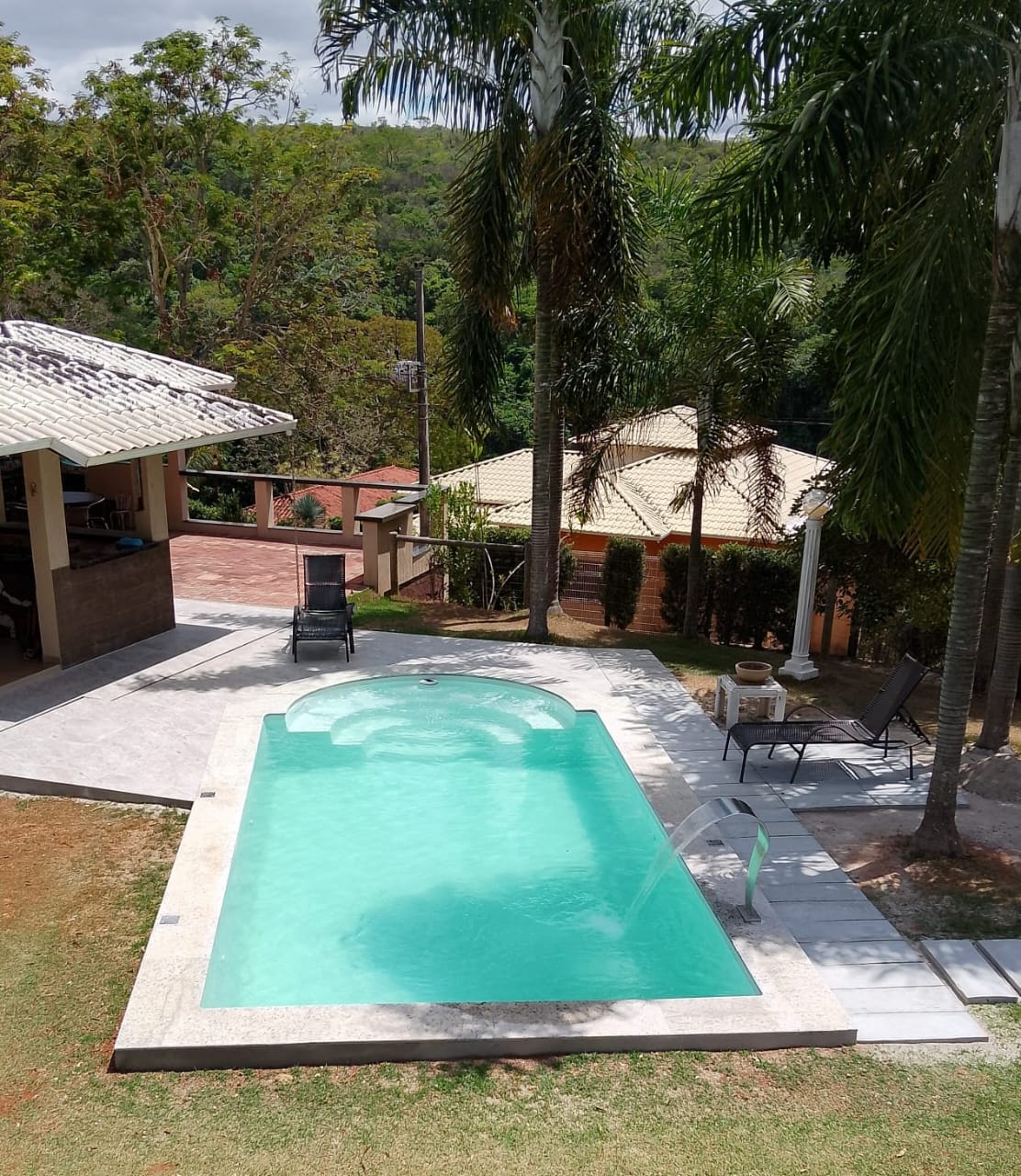 Piscina instalada com deck e cascata